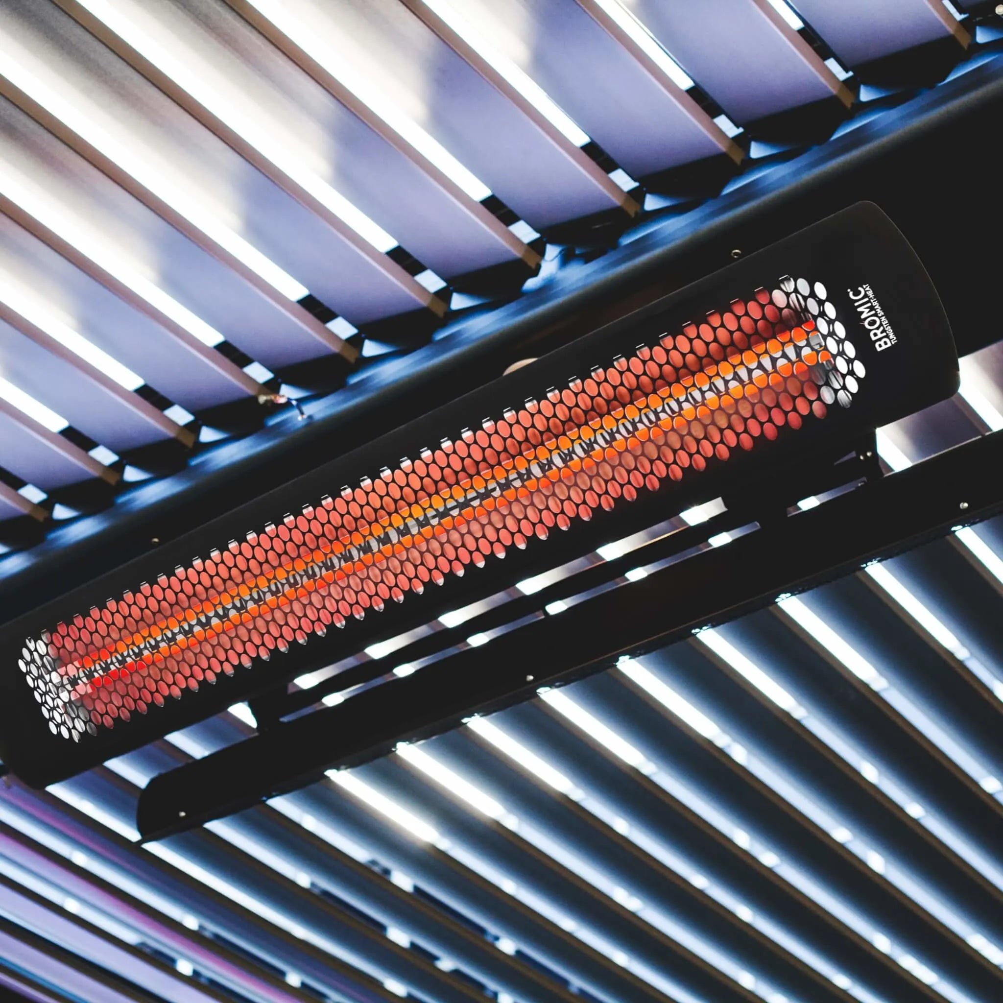 Commercial restaurant space featuring Bromic Tungsten Electric Smart-Heat Heaters mounted to the ceiling, creating a warm and inviting environment for guests in a stylish cafÃ© setting.