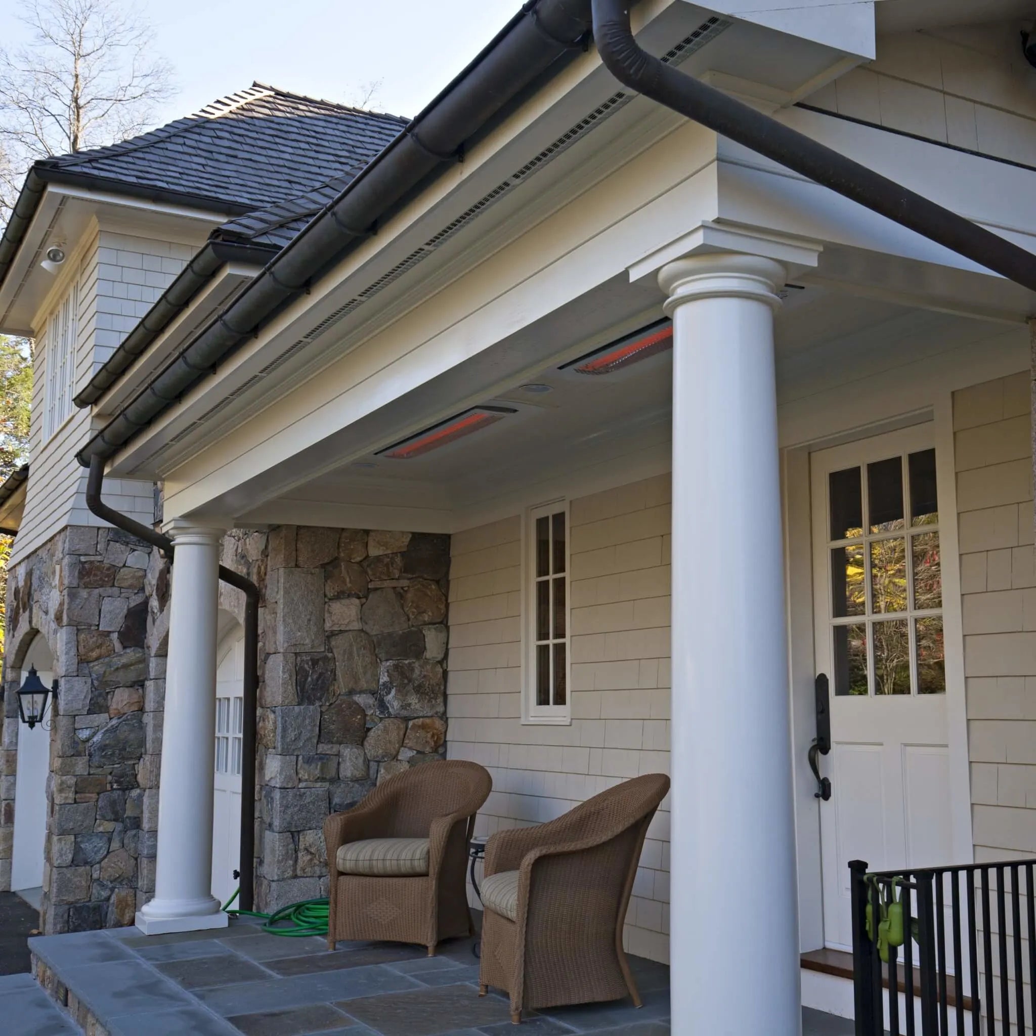 Front porch with recessed Bromic Tungsten Electric Smart-Heat heaters built into the white ceiling, offering discreet, comfortable warmth for a charming seating area.